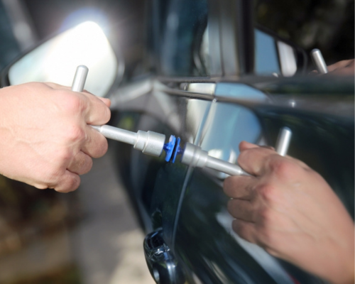 Paintless dent repair in Iowa City, IA, by Harv’s Auto Body Repair. Image of a technician using specialized tools to perform paintless dent repair on a vehicle, showcasing the precision and skill involved in the PDR process.