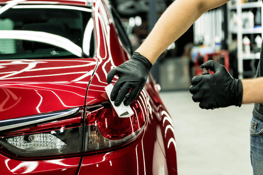 ceramic coating, auto body repair in Iowa City, IA at Harv's Auto Body Repair. Image of professional auto detailing in progress on a vibrant red car.