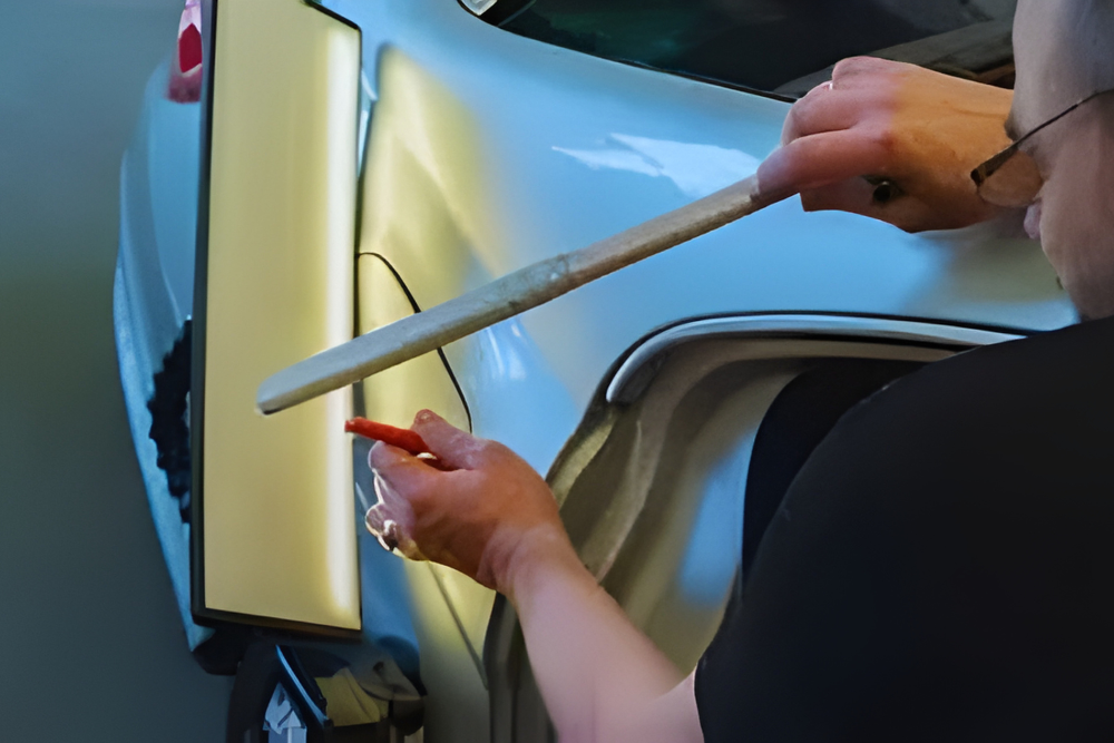 Dent Removal and Body Repair in Iowa City IA At Harv's Auto Body Repair. Professional technician working on pdr to fix vehicle body dent.